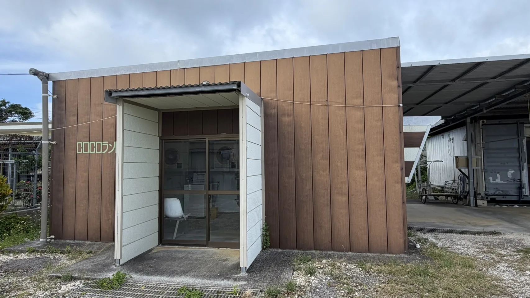 コインランドリーの建物外観と入口に見える洗濯機